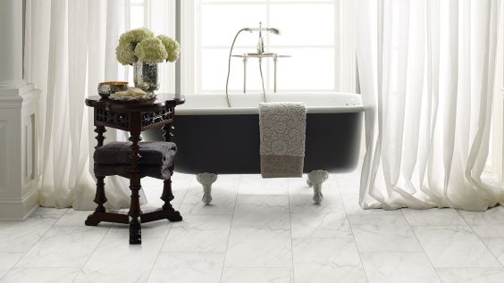 marble tile flooring in a classy white bathroom with freestanding porcelain tub